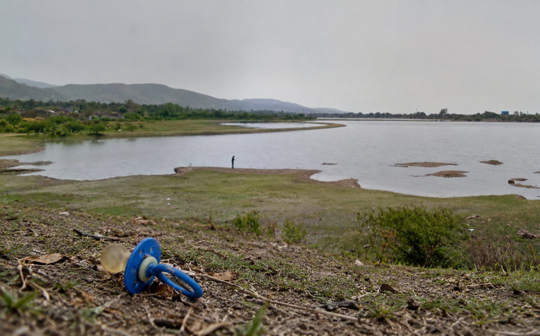 Chupete azul junto al lago gris